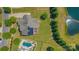 Aerial shot of a home with a pool, pond, deck, manicured yard, and solar panels on the roof at 11333 Preservation Ln, Charlotte, NC 28278