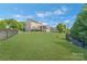 Expansive, well-maintained backyard with lush green grass, black fence, and a view of the home's rear at 11333 Preservation Ln, Charlotte, NC 28278