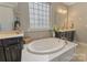 Luxurious bathroom with a soaking tub, double vanity, and stylish finishes at 11333 Preservation Ln, Charlotte, NC 28278