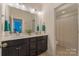 Double sink bathroom with modern lighting, dark cabinetry, and separate shower area at 11333 Preservation Ln, Charlotte, NC 28278