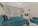 Cozy bedroom featuring natural light, plush bed with blue comforter, and accent decor at 11333 Preservation Ln, Charlotte, NC 28278