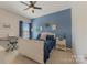 Charming bedroom featuring a white bed with blue bedding, piano and soft natural light at 11333 Preservation Ln, Charlotte, NC 28278