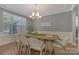 Elegant dining room with a chandelier, large window, and a modern dining set at 11333 Preservation Ln, Charlotte, NC 28278