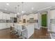 Spacious kitchen featuring a large island with bar seating, stainless steel appliances, and white cabinetry at 11333 Preservation Ln, Charlotte, NC 28278