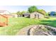 Large grassy backyard with a covered patio, brick building, fire pit, and mature trees at 125 Southwood Park, Mooresville, NC 28117