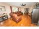 Bright living room with hardwood floors, a ceiling fan, and a comfortable leather sectional at 125 Southwood Park, Mooresville, NC 28117