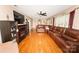 Spacious living room featuring hardwood floors, a fireplace and a large leather couch at 125 Southwood Park, Mooresville, NC 28117
