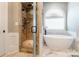Elegant bathroom showcasing a glass-enclosed shower and a modern soaking tub under an arched window at 1260 Rittenhouse Ln, Rock Hill, SC 29732