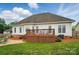 View of the backyard with a deck, stone patio, and well-maintained lawn at 129 Daniel Efird Dr, Mount Holly, NC 28120