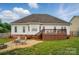 Backyard view with a stone patio, chairs, table, and a wooden deck at 129 Daniel Efird Dr, Mount Holly, NC 28120