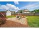 Charming backyard featuring a stone patio, fire pit, and a well-maintained lawn at 129 Daniel Efird Dr, Mount Holly, NC 28120
