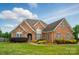 Charming brick home featuring manicured lawn and lush landscaping at 129 Daniel Efird Dr, Mount Holly, NC 28120
