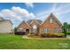 Charming brick home featuring manicured lawn and lush landscaping at 129 Daniel Efird Dr, Mount Holly, NC 28120
