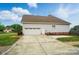 Side view of home featuring a two car garage and driveway surrounded by green grass at 129 Daniel Efird Dr, Mount Holly, NC 28120