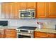 Updated kitchen featuring stainless steel appliances, granite countertops, and warm wood cabinetry at 129 Daniel Efird Dr, Mount Holly, NC 28120