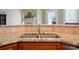 Close up on the kitchen sink with granite countertops and warm wood cabinetry at 129 Daniel Efird Dr, Mount Holly, NC 28120