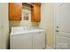 A functional laundry room with cabinetry above a washer and dryer at 129 Daniel Efird Dr, Mount Holly, NC 28120