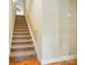 Carpeted stairway featuring wood handrail connects upper and lower levels at 129 Daniel Efird Dr, Mount Holly, NC 28120