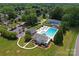 An aerial view features a community pool, tennis courts, clubhouse, and ample parking surrounded by lush trees and greenery at 13430 Norseman Ln, Huntersville, NC 28078