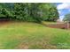 The backyard has a well-kept lawn with mature trees, providing ample shade and a peaceful setting at 13430 Norseman Ln, Huntersville, NC 28078
