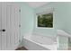 This primary bathroom offers a soaking tub next to a window overlooking a private backyard at 13430 Norseman Ln, Huntersville, NC 28078
