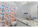 This bathroom offers a single sink, granite countertops and a peach-themed shower curtain at 13430 Norseman Ln, Huntersville, NC 28078