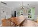 Dining area with a large rustic table, stylish chandelier, and natural light at 13430 Norseman Ln, Huntersville, NC 28078