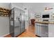 Kitchen with stainless steel refrigerator and view into living room with fireplace and built-in shelving at 13430 Norseman Ln, Huntersville, NC 28078