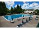 A well-maintained community pool is surrounded by lounge chairs and tables with umbrellas for a relaxing atmosphere at 13430 Norseman Ln, Huntersville, NC 28078