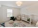Serene Bedroom with a crib, comfy chair, and soft rug, creating a peaceful environment for baby at 1381 Regions Blvd, Fort Mill, SC 29707