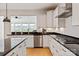 Bright kitchen showcasing an island, stainless steel appliances, white cabinetry and modern black countertop at 1381 Regions Blvd, Fort Mill, SC 29707