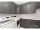 Functional laundry room with ample cabinets, counter space, and modern washer and dryer units at 1381 Regions Blvd, Fort Mill, SC 29707