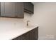 Convenient laundry area featuring a sink, plenty of counter space, and stylish gray cabinetry at 1381 Regions Blvd, Fort Mill, SC 29707