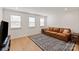 Bright living room with hardwood floors, leather sofa, and stylish rug, perfect for relaxation at 1381 Regions Blvd, Fort Mill, SC 29707