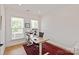 Well-lit home office featuring hardwood floors, large windows, and a spacious desk setup on a vibrant red rug at 1381 Regions Blvd, Fort Mill, SC 29707