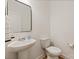 Bright powder room featuring a pedestal sink, modern toilet, and neutral wall color at 1381 Regions Blvd, Fort Mill, SC 29707