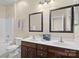 Bright bathroom with double sinks, dark wood cabinets, and a shower-tub combination at 15247 Prescott Hill Ave, Charlotte, NC 28277