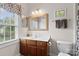 Charming bathroom with a framed mirror, and a wooden vanity with a solid surface countertop at 15247 Prescott Hill Ave, Charlotte, NC 28277