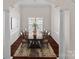 Formal dining room with a long wooden table, chandelier, and elegant columns at 15247 Prescott Hill Ave, Charlotte, NC 28277