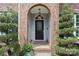 Close-up of the front door with decorative glass, brick archway, and manicured landscaping at 15247 Prescott Hill Ave, Charlotte, NC 28277