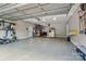 Epoxy floor garage with tools on the wall, lawn equipment, and stainless fridge at 15247 Prescott Hill Ave, Charlotte, NC 28277
