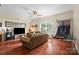 Spacious living room with hardwood floors, couch, TV, and a basketball game set at 15247 Prescott Hill Ave, Charlotte, NC 28277