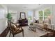Cozy living room with neutral decor, hardwood floors, and ample natural light from large windows at 15247 Prescott Hill Ave, Charlotte, NC 28277