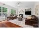 Inviting living room featuring a fireplace, built-in shelving, hardwood floors, and abundant natural light at 15247 Prescott Hill Ave, Charlotte, NC 28277