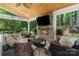 Inviting covered patio with stone fireplace, TV, and comfortable seating provides a cozy outdoor living space at 15247 Prescott Hill Ave, Charlotte, NC 28277