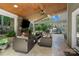Covered outdoor patio with a stone fireplace, ceiling fan, grill and comfortable seating area at 15247 Prescott Hill Ave, Charlotte, NC 28277