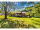 Expansive backyard with lush green lawn, mature trees, and brick house exterior at 157 E Meadowview Dr, Statesville, NC 28625