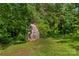 An exterior view of a charming barn surrounded by trees showcases the rustic charm of the property at 157 E Meadowview Dr, Statesville, NC 28625