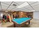 Basement area with pool table, golf clubs, storage, and brick fireplace at 157 E Meadowview Dr, Statesville, NC 28625