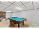 Unfinished basement features a pool table, brick fireplace, and concrete flooring at 157 E Meadowview Dr, Statesville, NC 28625